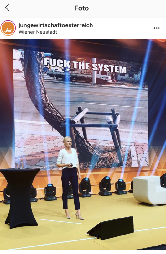 JW Summit · Henriette Frädrich als Eröffnungs-Speakerin auf der Bühne der Jungen Wirtschaft Österreich vor „Fuck the System“-Backdrop · Wiener Neustadt · 25.09.2020